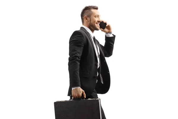 若いビジネスマンは白い背景に隔離された携帯電話で歩くと話している — ストック写真