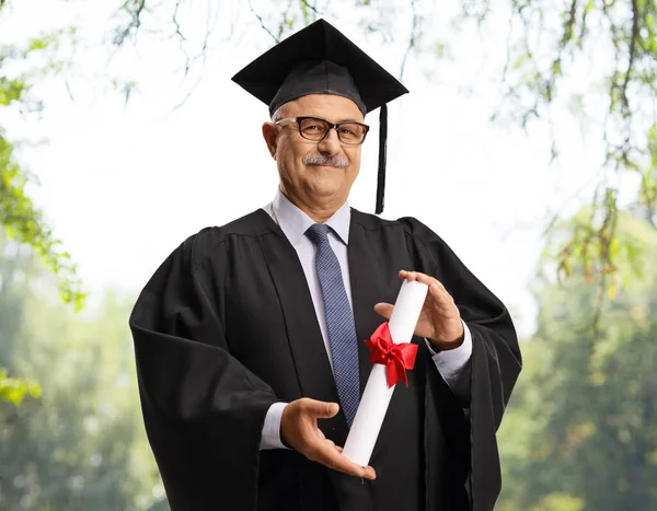 Maduro Homem Vestido Graduação Segurando Diploma Livre Com Árvores Fundo — Fotografia de Stock