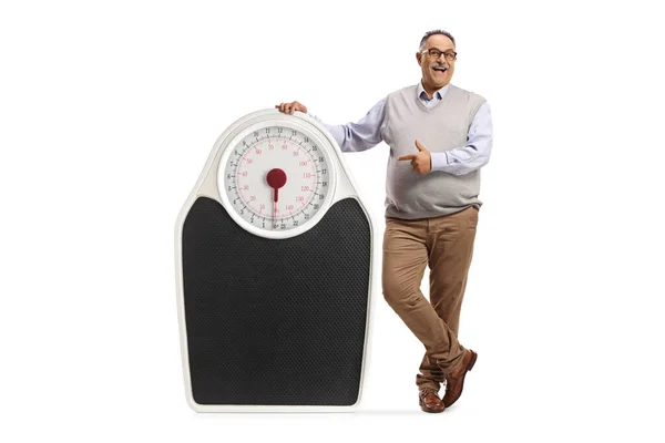 Full Length Portrait Mature Man Leaning Big Weighing Scale Pointing — Stock Photo, Image