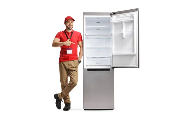 Einzelhandelskauffrau Lehnt Kühlschrank Und Zeigt Vereinzelt Auf Weißen Hintergrund — Stockfoto