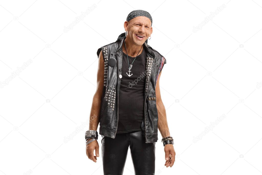 Cheerful punk in a leather outfit smiling at the camera isolated on white background