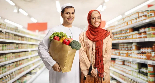 Młoda Muzułmańska Para Supermarkecie Trzymająca Papierową Torbę Zakupy Zakupami Pozująca — Zdjęcie stockowe