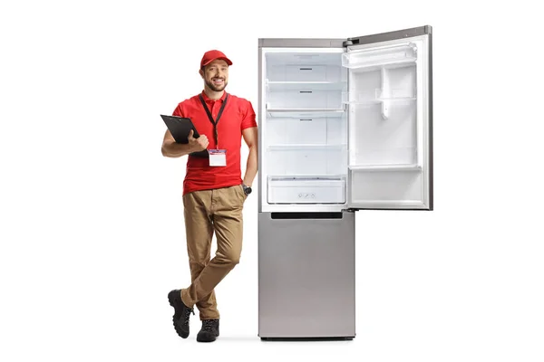 Männliche Verkäuferin Lehnt Einem Kühlschrank Und Hält Ein Klemmbrett Isoliert — Stockfoto