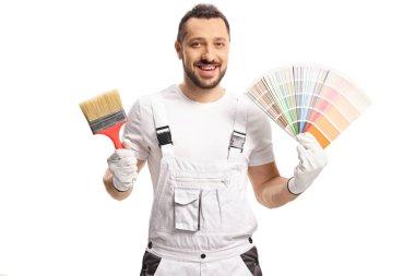 Beyaz üniformalı bir ressam elinde bir renk paleti ve beyaz arkaplanda izole edilmiş bir fırça tutuyor.