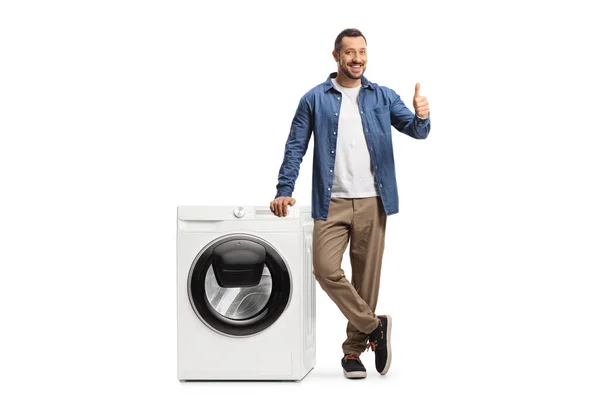 Jongeman Staat Naast Een Wasmachine Toont Duimen Omhoog Geïsoleerd Witte — Stockfoto