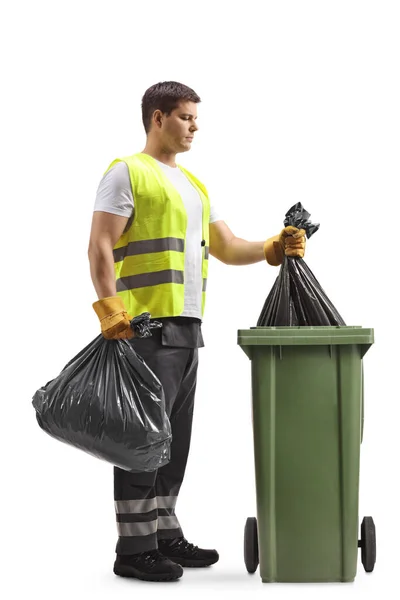 一个年轻的废物收集者从一个白色背景的垃圾桶中取出一个袋子的全景照片 — 图库照片