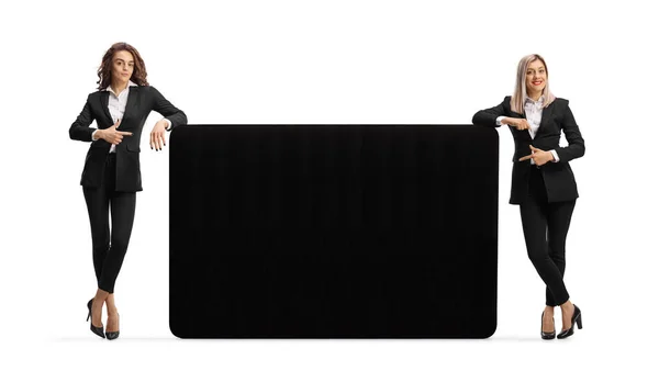 Businesswomen Leaning Black Panel Pointing Isolated White Background — Stock Photo, Image