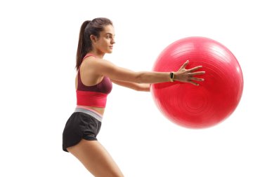 Beyaz arka planda izole edilmiş bir fitness topu tutan bir kadının profil fotoğrafı.