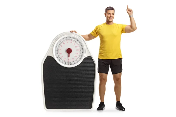 Full Length Portrait Young Man Sportswear Leaning Big Scale Pointing — Stock Photo, Image