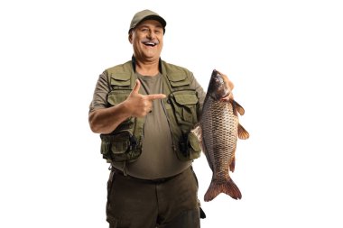Mature fisherman holding a big carp fish and pointing isolated on white background
