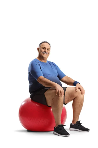 Lächelnder Älterer Mann Sitzt Auf Einem Roten Fitnessball Auf Weißem — Stockfoto