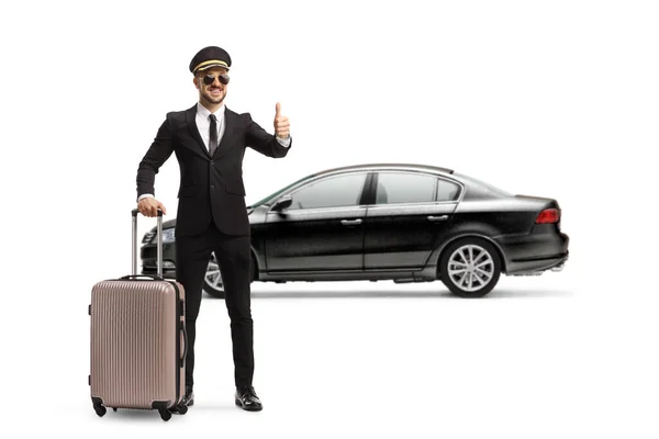 黒い車の前にスーツケース付きの運転手の完全な長さの肖像画白い背景に隔離された親指をジェスチャー — ストック写真