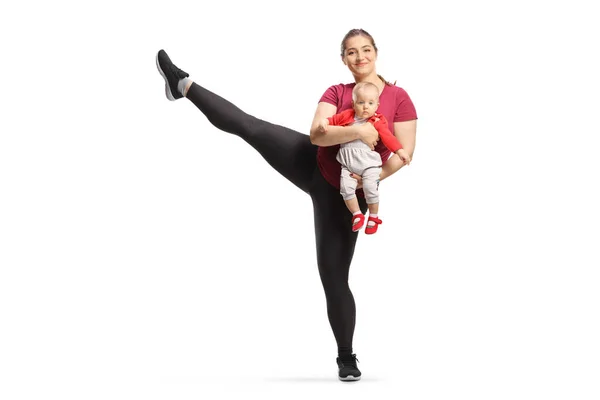 Całkowity Profil Ujęcia Matki Ćwiczącej Podnoszącej Nogę Trzymającej Dziecko Odizolowane — Zdjęcie stockowe