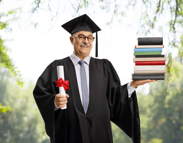 Reifer Mann Abschlusskleid Mit Abschlusszeugnis Und Einem Stapel Bücher Freien — Stockfoto