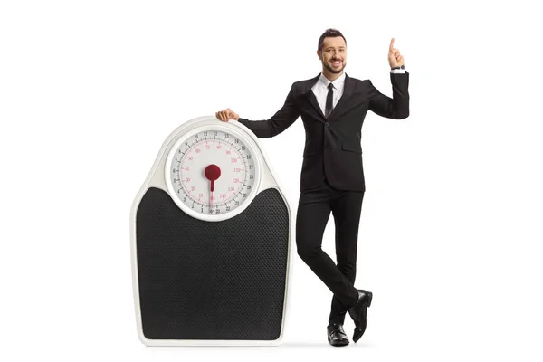 Full Length Portrait Businessman Leaning Big Weight Scale Pointing Isolated — Stock Photo, Image