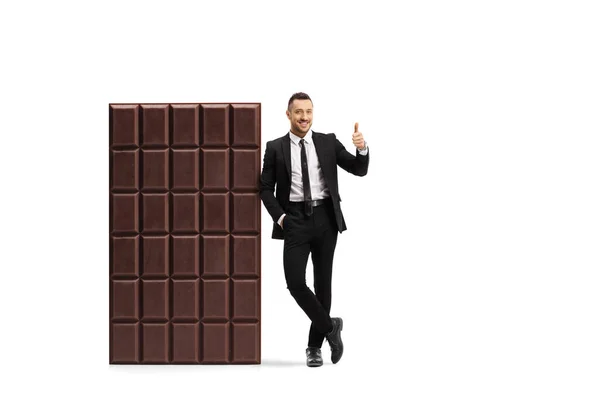 Full Length Portret Van Een Zakenman Leunend Een Grote Chocoladereep — Stockfoto
