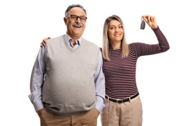 Baba ve kızı araba anahtarını beyaz arka planda gösteriyorlar.