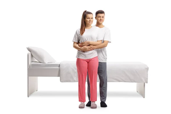 Jong Paar Pyjama Staan Omhelzing Voorkant Van Een Bed Geïsoleerd — Stockfoto