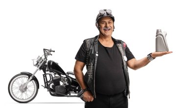 Beyaz arka planda izole edilmiş motor yağı şişesini elinde tutan bir helikopteri olan olgun bir motorcu.