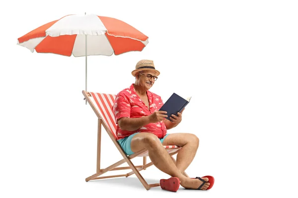 一个拿着一本书坐在贝叶椅上 在白色背景的伞下看书的人 — 图库照片