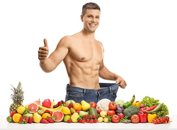 Młody Człowiek Owocami Warzywami Dużych Dżinsach Kciukach Białym Tle — Zdjęcie stockowe