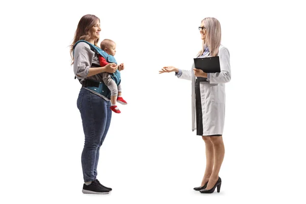 一位女妇科医生与一位在白色背景下与一位带着孩子的母亲交谈时拍摄的全景照片 — 图库照片