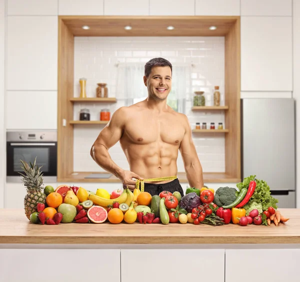 Fisiculturista Medindo Sua Cintura Atrás Uma Pilha Frutas Legumes Uma — Fotografia de Stock