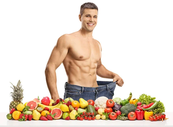 Fit Człowiek Bez Koszuli Ponadgabarytowych Dżinsach Stojąc Stos Świeżych Owoców — Zdjęcie stockowe