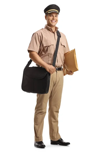 バッグと白い背景に隔離された手紙を運ぶ制服を着た若い郵便配達人の完全な長さの肖像画 — ストック写真