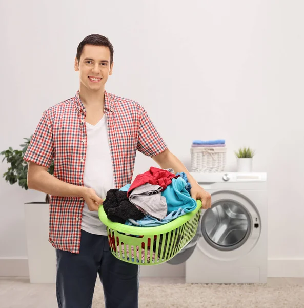 Glimlachende Jongeman Die Thuis Een Wasmand Draagt — Stockfoto