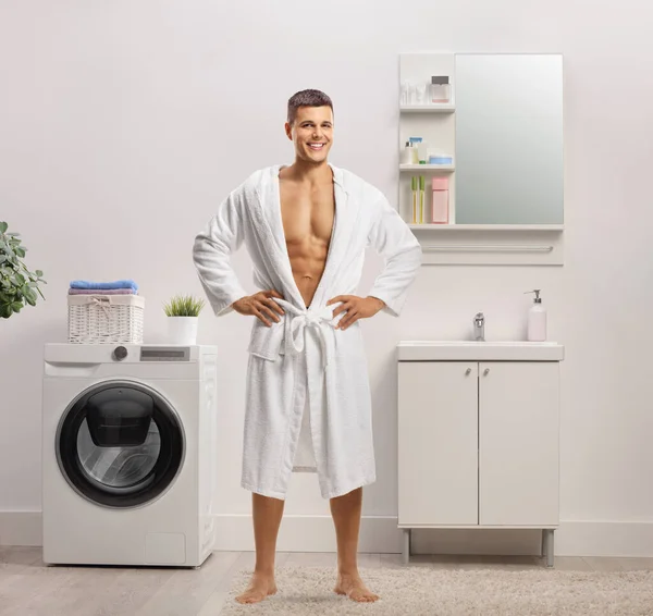 浴室の中に白いバスローブを着た裸の男の完全な長さの肖像画 — ストック写真
