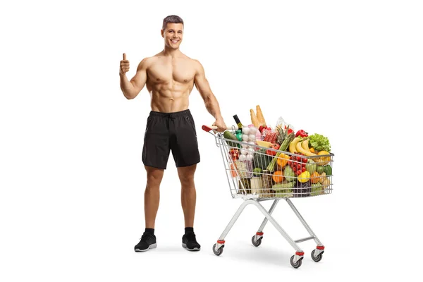 Hombre Deportivo Sin Camisa Con Carrito Compras Lleno Comida Mostrando — Foto de Stock