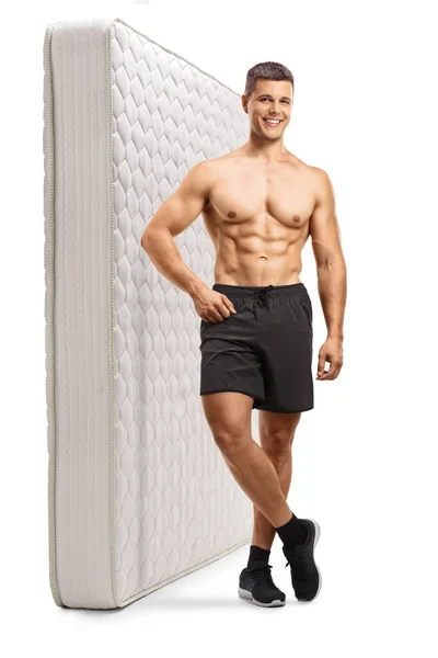 全长的画像 一个没有肌肉的男人靠着床垫靠在白色的背景上 — 图库照片
