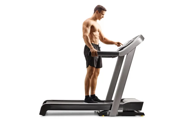 Full Length Profile Shot Shirtless Young Man Setting Program Treadmill — Stockfoto