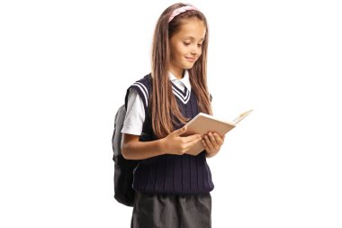Üniformalı mutlu kız öğrenci beyaz arka planda izole edilmiş bir kitap okuyor.