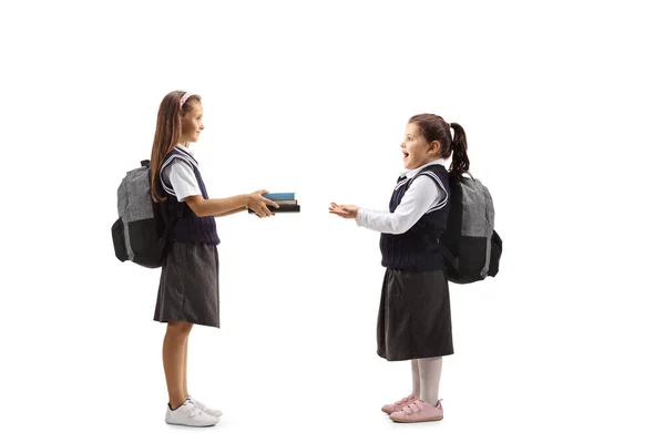 Estudante Dando Livros Para Uma Menina Feliz Uniforme Escolar Isolado — Fotografia de Stock