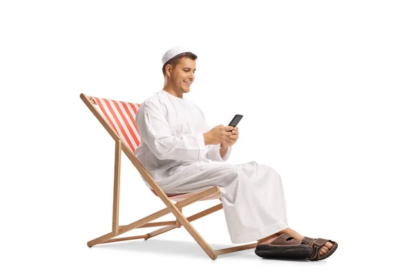 Молодий Чоловік Етнічному Одязі Сидить Пляжному Кріслі Мобільним Телефоном Ізольовано — стокове фото