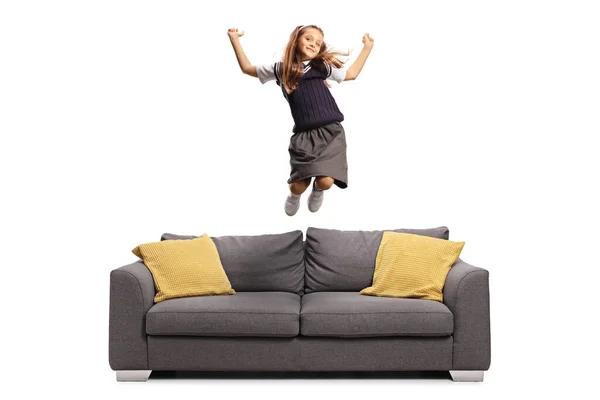 Glückliche Schulmädchen Uniform Springen Auf Einem Sofa Isoliert Auf Weißem — Stockfoto