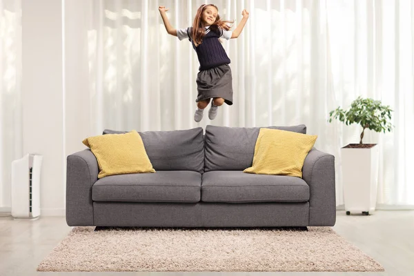 Aufgeregtes Schulmädchen Uniform Springt Hause Auf Ein Sofa — Stockfoto