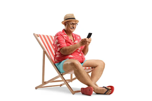 Oudere Man Ontspannen Een Strandstoel Met Behulp Van Een Smartphone — Stockfoto