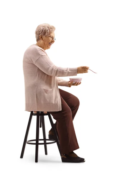 Starsza Kobieta Siedząca Karmiąca Łyżką Białym Tle — Zdjęcie stockowe