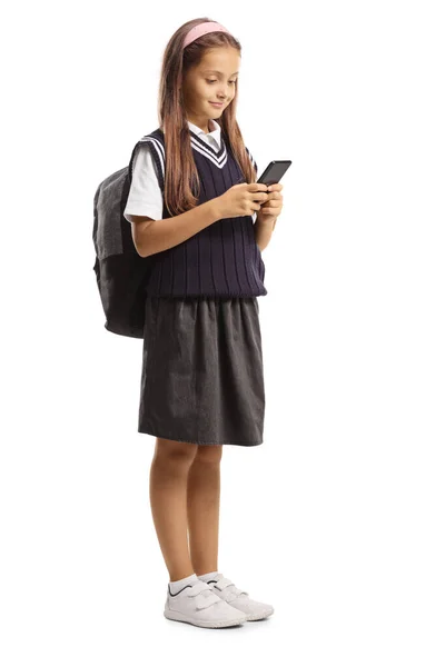 Iskoláslány Iskolai Egyenruhában Áll Egy Fehér Alapon Izolált Mobiltelefont Használ — Stock Fotó