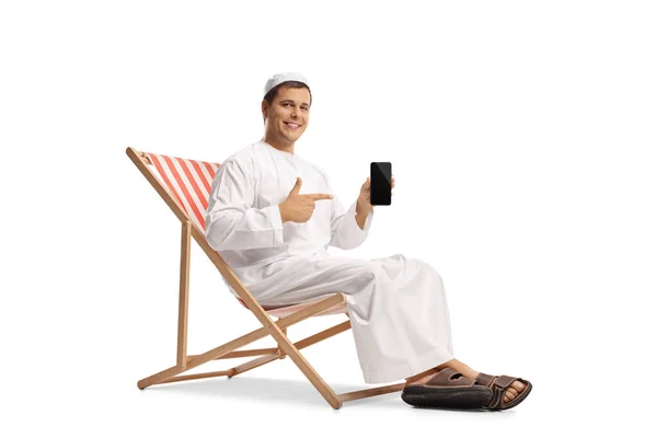 Jovem Roupas Étnicas Sentado Uma Cadeira Praia Apontando Para Telefone — Fotografia de Stock