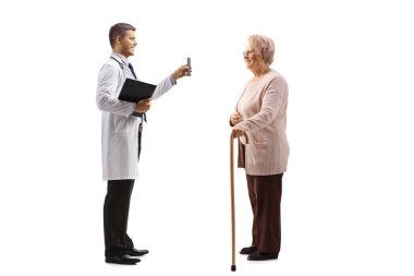 Genç bir erkek doktor, beyaz arka planda izole edilmiş yetişkin bir kadın hastaya cep telefonunu gösteriyor. 