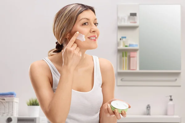 浴室の中で顔クリームを適用若い女性 — ストック写真