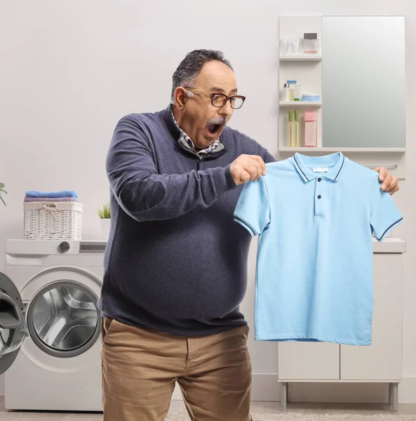 Shocked Mature Man Holding Shrunken Shirt Bathroom — Stock Photo, Image