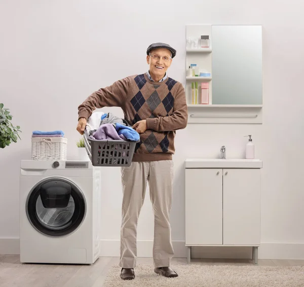 Smiling Elderly Man Holding Laundry Basket Full Clothes Bathroom — Stock Photo, Image