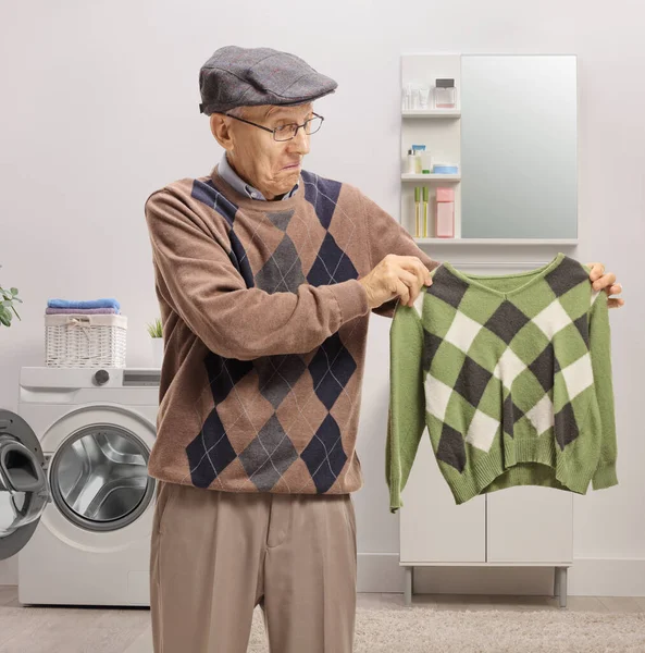 Disappointed Elderly Man Holding Shrunken Blouse Bathroom — Stock Photo, Image