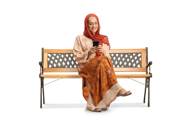 Женщина Этнической Одежде Хиджабе Сидит Скамейке Помощью Смартфона Изолированы Белом — стоковое фото