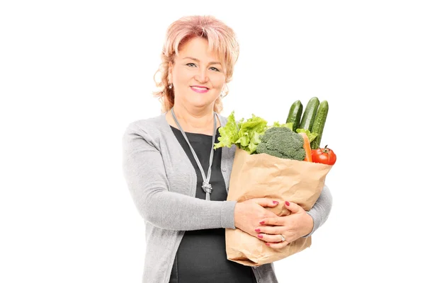 Mature lady holding bag with groceries — Stock Photo, Image